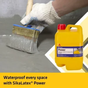 A person wearing gloves uses a brush to apply a SikaLatex Power waterproofing polymer to a gray surface. A yellow container of SikaLatex Power is visible to the right.